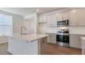 Modern kitchen with stainless appliances, gray cabinets, white countertops, and a kitchen island at 2318 Sugar Cone Way, Fuquay Varina, NC 27526