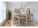 Light and bright dining room with hardwood floors, stylish chandelier, and neutral decor at 2404 Gillingham Dr, Apex, NC 27539