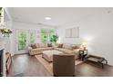 Bright living room featuring hardwood floors, a large sofa, and access to the outdoors at 2651 Mellow Field Dr # 206, Raleigh, NC 27604