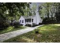 Beautiful home with a well-manicured lawn, mature trees, and inviting front porch at 300 Round About Rd, Holly Springs, NC 27540