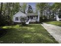 Attractive home with blue shutters and a welcoming front porch, set in a lush green yard at 300 Round About Rd, Holly Springs, NC 27540