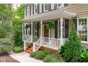 Inviting front porch with white railings, hanging plants, and a wooden front door at 307 Parkmeadow Dr, Cary, NC 27519