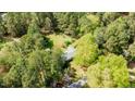 An aerial view of a home nestled within a lush, green landscape showcasing the surrounding trees and ample yard space at 310 Edward Ln, Louisburg, NC 27549