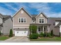 Charming two-story home featuring a covered front porch, two-car garage, and well-maintained landscaping at 3262 Ripley River Rd, New Hill, NC 27562