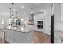 Modern kitchen with white cabinets, granite countertops, stainless steel appliances and stylish pendant lighting at 3262 Ripley River Rd, New Hill, NC 27562