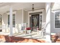 Inviting front porch with rocking chairs, swing, and decorative door at 3908 Yateswood Ct, Raleigh, NC 27603