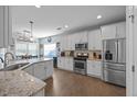 Bright, modern kitchen featuring stainless steel appliances, granite countertops, and hardwood floors at 405 Club Center Dr, Youngsville, NC 27596