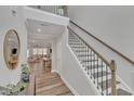 Bright foyer features hardwood floors, an elegant staircase, and views into the living and dining areas at 4905 Abundance Ave, Raleigh, NC 27616