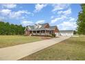 Desirable brick home with a long driveway, detached garage, and appealing front porch, set on a large lot at 495 Evans Rd, Princeton, NC 27569