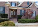 Elegant brick home featuring a beautiful front door with sidelights, and professionally landscaped front yard at 502 Sippihaw Oaks Dr, Fuquay Varina, NC 27526