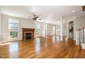 Spacious living room boasts hardwood floors, large windows, fireplace, and elegant columns, creating an inviting space at 502 Sippihaw Oaks Dr, Fuquay Varina, NC 27526