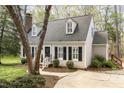 Charming home boasts manicured landscaping, dark shutters, a brick chimney, and a walkway leading to the front door at 520 Tall Oaks Dr, Durham, NC 27713