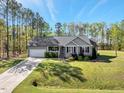 Attractive single-story home with manicured lawn, attached garage, covered entry, and beautiful landscaping at 55 Northdale Ct, Louisburg, NC 27549