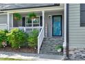 Inviting front porch with decorative plants, a stone staircase, and a blue front door at 55 Northdale Ct, Louisburg, NC 27549