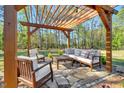 Outdoor patio area features elegant seating beneath a wooden pergola, perfect for entertaining guests at 55 Northdale Ct, Louisburg, NC 27549