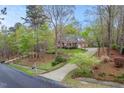 Brick home surrounded by mature trees, featuring a long driveway and lush landscaping at 5900 Orchid Valley Rd, Raleigh, NC 27613