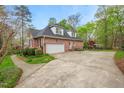 Brick home's side view features a large garage and spacious driveway with curb side garden at 5900 Orchid Valley Rd, Raleigh, NC 27613