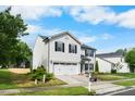 Well-manicured two-story home featuring a two-car garage, neat lawn, and classic design elements under a blue sky at 6102 Coronado Ln, Durham, NC 27713