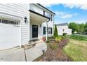Inviting front entrance with manicured landscaping, a black front door, and a well-maintained lawn at 6102 Coronado Ln, Durham, NC 27713
