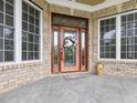 Elegant front entry with a stained wood door, leaded glass sidelights, and decorative brickwork at 642 Bear Tree Creek, Chapel Hill, NC 27517