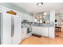 Well-lit kitchen featuring stainless steel appliances, tile backsplash, and white cabinetry at 707 Cross Timbers Dr, Durham, NC 27713