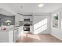 Well-lit kitchen with white cabinetry, stainless steel appliances, and a functional design at 7715 Bernadette Ln, Raleigh, NC 27615