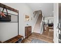 Entryway with wood-look flooring, coat rack, shoe storage, mirror and stairway at 95 Little Leaf Lane Ln, Clayton, NC 27527