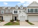 View of the townhome exterior featuring a one car garage, traditional facade, a black front door and a small green yard at 95 Little Leaf Lane Ln, Clayton, NC 27527
