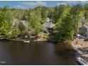 Beautiful waterfront property with mature trees, lush landscaping, and dock access on a serene lake setting at 955 Sagamore Dr, Louisburg, NC 27549