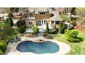 Aerial view of the home featuring a backyard with a pool, deck, gazebo and landscaped yard at 10001 Sandcreek Ct, Chapel Hill, NC 27517