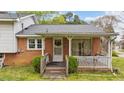 Charming brick home featuring a cozy covered porch and well-maintained landscaping at 101 W Thorndale Dr, Oxford, NC 27565