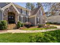 Close-up of the house's entrance showing stone archway, stairs, and manicured bushes at 102 Kamprath Pl, Cary, NC 27519