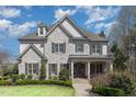 Stately stone home with a well-kept lawn and inviting entrance on a sunny day at 104 Vervain Way, Holly Springs, NC 27540