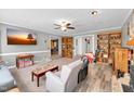 Open-concept living room with wood-look flooring, ceiling fan, and view into dining area at 105 Hobson Pl, Louisburg, NC 27549