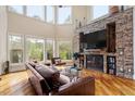 Bright living room features a stone fireplace, hardwood floors, and large windows with scenic views at 11 Swallow Tail Ct, Pittsboro, NC 27312