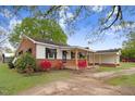 Quaint single-story house featuring brick accents, shutters, and a cozy covered porch at 1149 Us-701 Hwy, Four Oaks, NC 27524