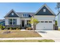 Charming home with a two-car garage, stone accents, manicured lawn, and beautiful landscaping at 1165 Saint Cloud Loop, Apex, NC 27523