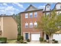Charming two-story brick townhome features a garage and a blue front door at 117 Gallent Hedge Trl, Apex, NC 27539