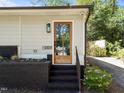 Charming front entrance featuring a glass paneled door, black brick accents, and landscaped garden area at 1307 Crabapple Ln, Raleigh, NC 27607