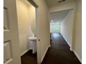 Stylish powder room featuring a pedestal sink and a view of the home's interior at 158 Parker Ln, Mebane, NC 27302