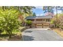 Welcoming home featuring a balcony, double garage, and well-maintained driveway, surrounded by blooming trees and greenery at 1705 Lord Ashley Dr, Sanford, NC 27330