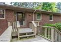 Charming brick home featuring a covered front porch and well-maintained landscaping at 1705 Lord Ashley Dr, Sanford, NC 27330
