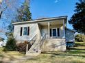 Charming home featuring a covered porch, black shutters, and a staircase leading to the entrance at 1716 Turner St, Roxboro, NC 27573