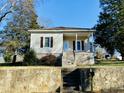 Charming home featuring a covered porch, black shutters, landscaped yard, and a staircase leading to the entrance at 1716 Turner St, Roxboro, NC 27573