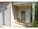 Charming front porch with 'hello' doormat, potted plants, and decorative wreath on the door at 1817 Heisser Ln, Fuquay Varina, NC 27526