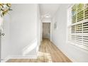 Bright hallway with light wood floors, white walls, and natural light streaming through the window at 1817 Heisser Ln, Fuquay Varina, NC 27526