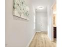 Hallway with wood floors leading to bathroom and a white paneled door at 1817 Heisser Ln, Fuquay Varina, NC 27526