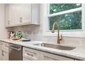 Granite counters and a stainless steel sink with gooseneck faucet are set under a window in this bright kitchen at 206 Bickett Blvd, Raleigh, NC 27608