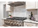 Gourmet kitchen featuring a professional-grade stainless steel gas range and bright backsplash at 206 Bickett Blvd, Raleigh, NC 27608