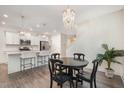 Bright dining area open to the kitchen, featuring a modern chandelier and stylish finishes at 210 Silas St, Durham, NC 27705